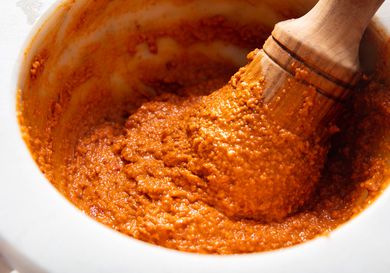 A pestle pounding ingredients for romesco sauce. 