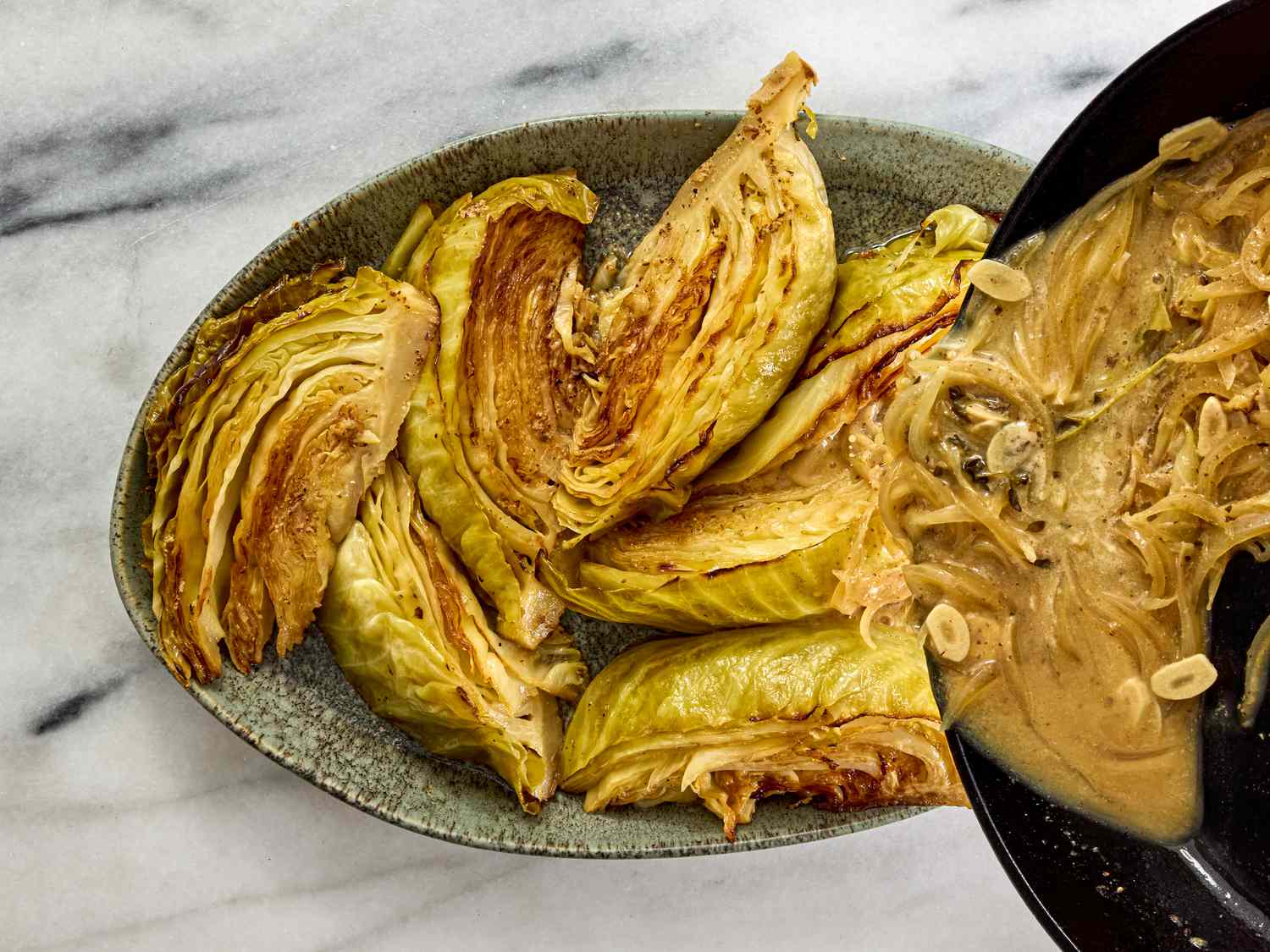 pouring sauce over cabbage on a serving platter