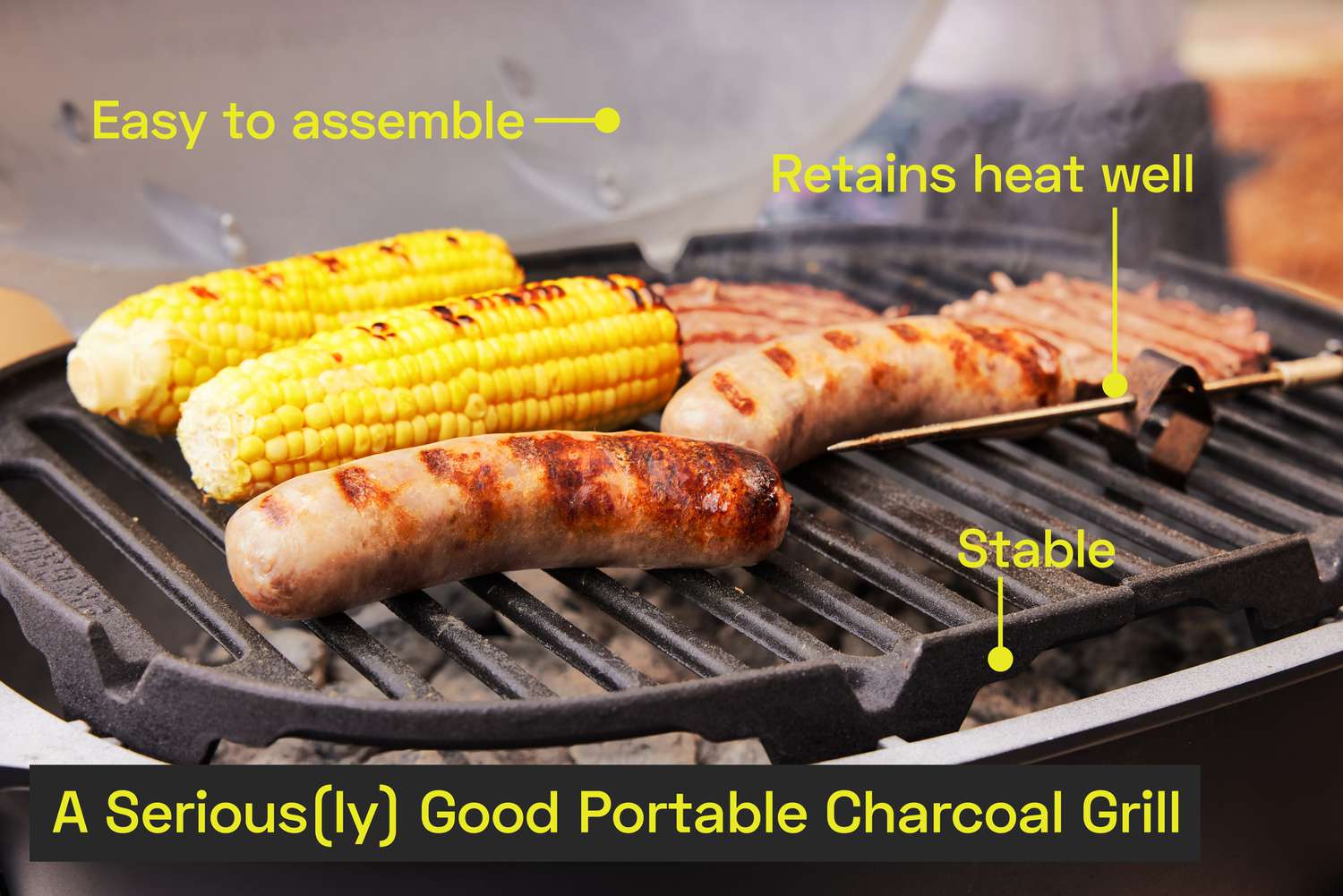 Sausage, corn on the cob, and burgers cooking on a portable charcoal grill.