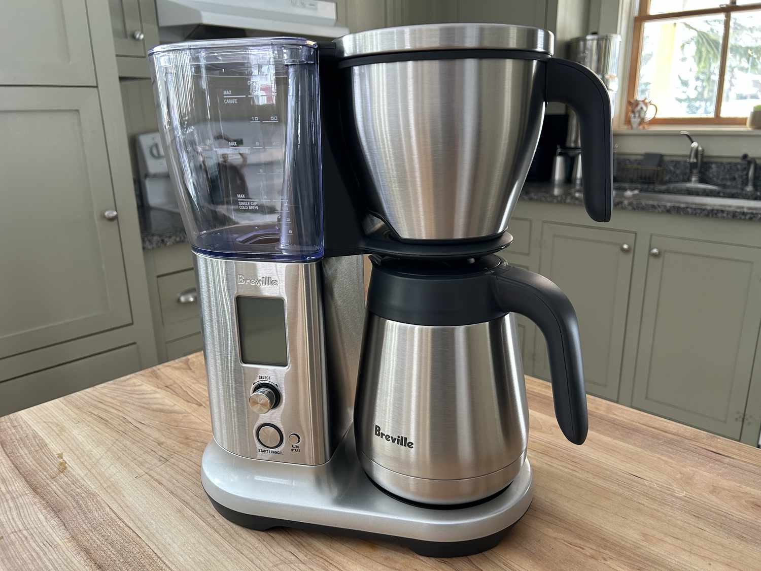 The Breville Precision coffee maker on a wooden table in a kitchen.