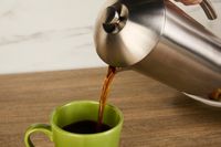 Coffee being poured from the Frieling French press into a mug.