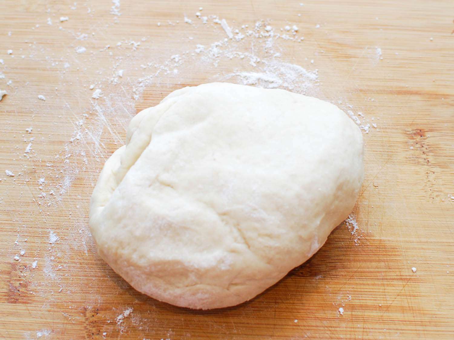 The rested dough is transferred to a cutting board.