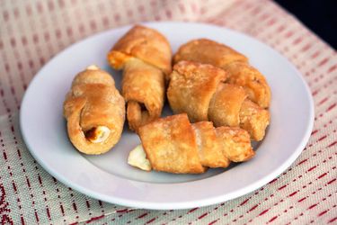 A small plate loaded with 5 churros de queso.
