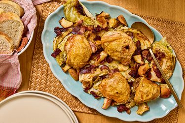 Sheet pan chicken thighs served with bacon and apple on a platter