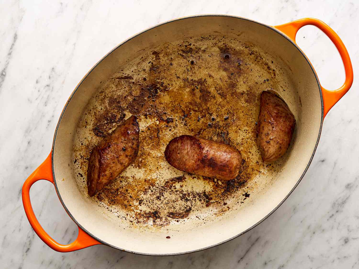 Sausages browning in a Dutch oven
