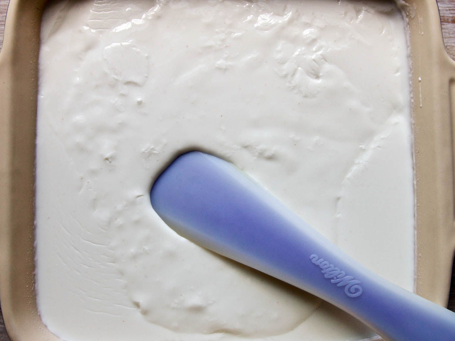 Overhead view of the coconut buttermilk mousse in a square baking dish, ready to refrigerate and set.