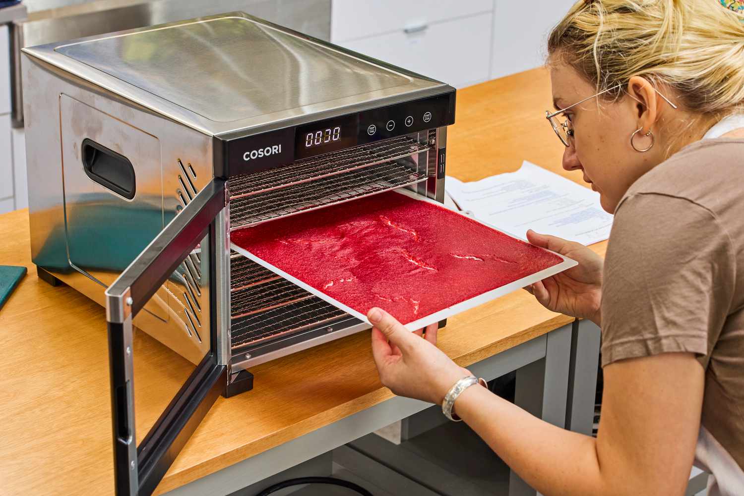 A person placing a food leather tray in COSORI Food Dehydrator