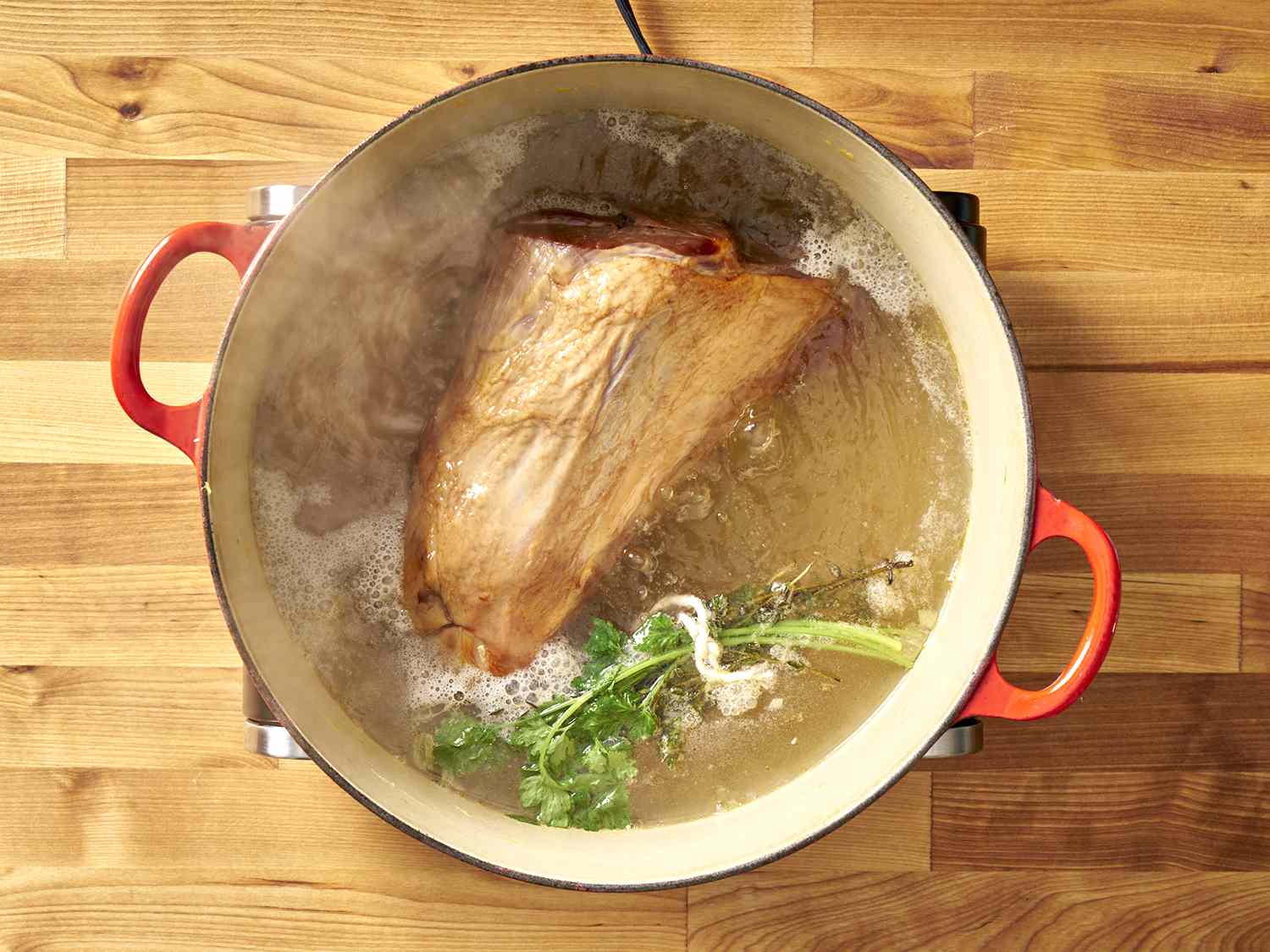 Ham hock and herbs boiling.