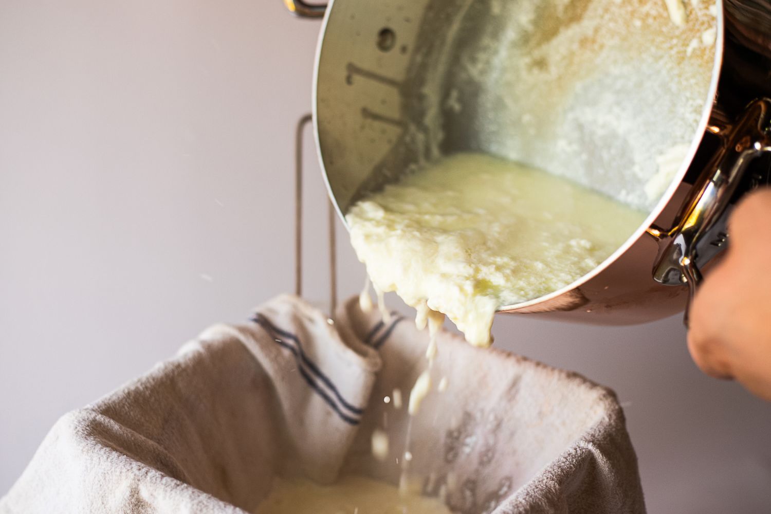 Liquid being poured from a pot onto a clothlined strainer