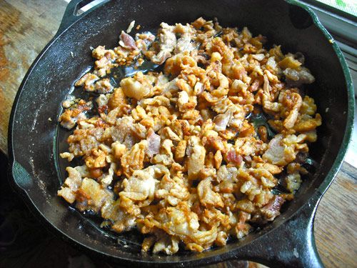 Bit of duck fat rendering in a large cast iron skillet