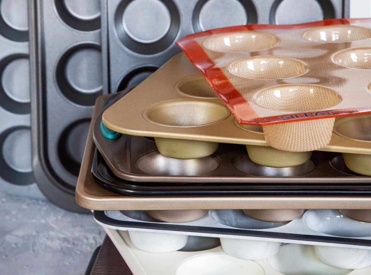 Muffin pans stacked on top of one another on counter