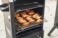 A closeup of a shelf of wings in the Cuisinart COS-244 Vertical Propane Smoker