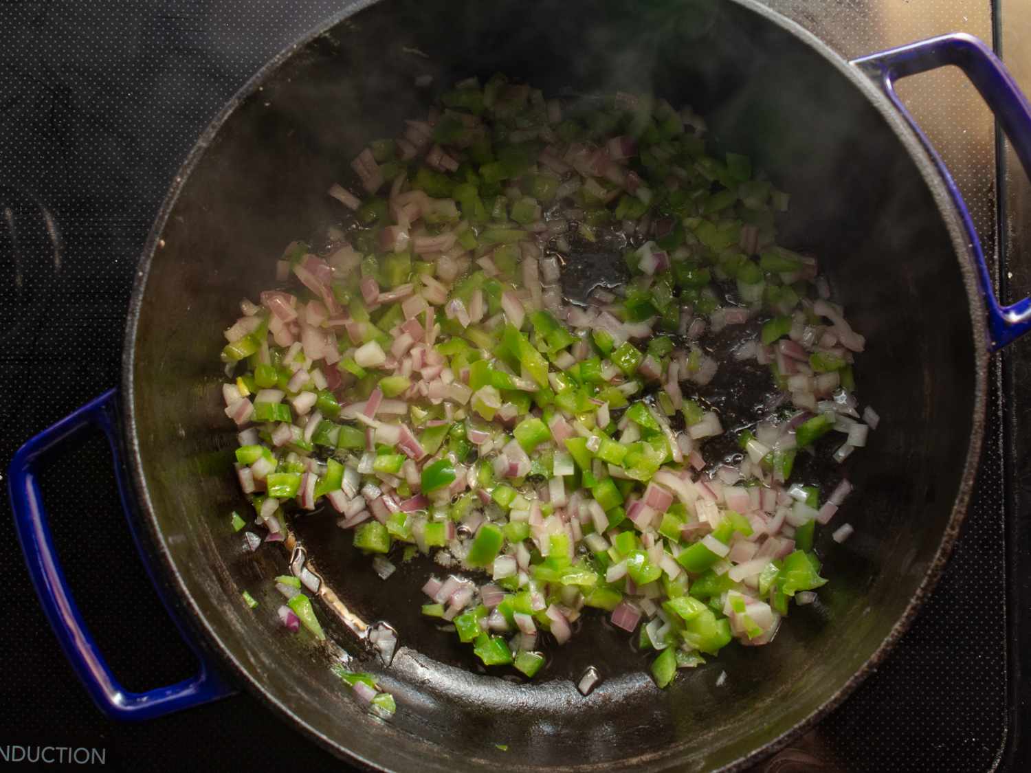 onion and green bell pepper cooking in a dutch oven
