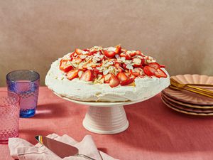 Strawberry pavlova dessert on a stand with table setting