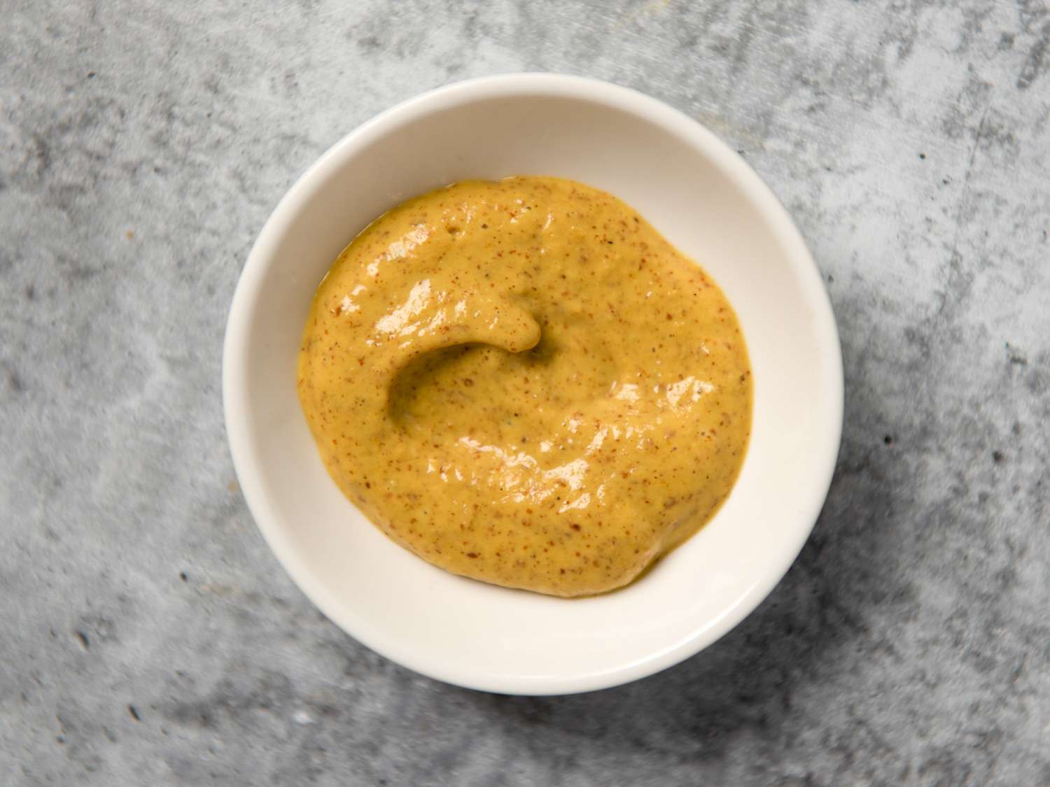 spicy brown mustard in a small white bowl