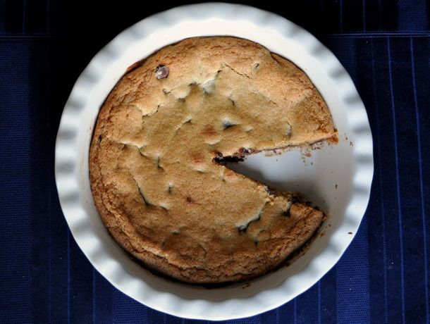 Chocolate chip cookie pie from overhead, with a slice missing..