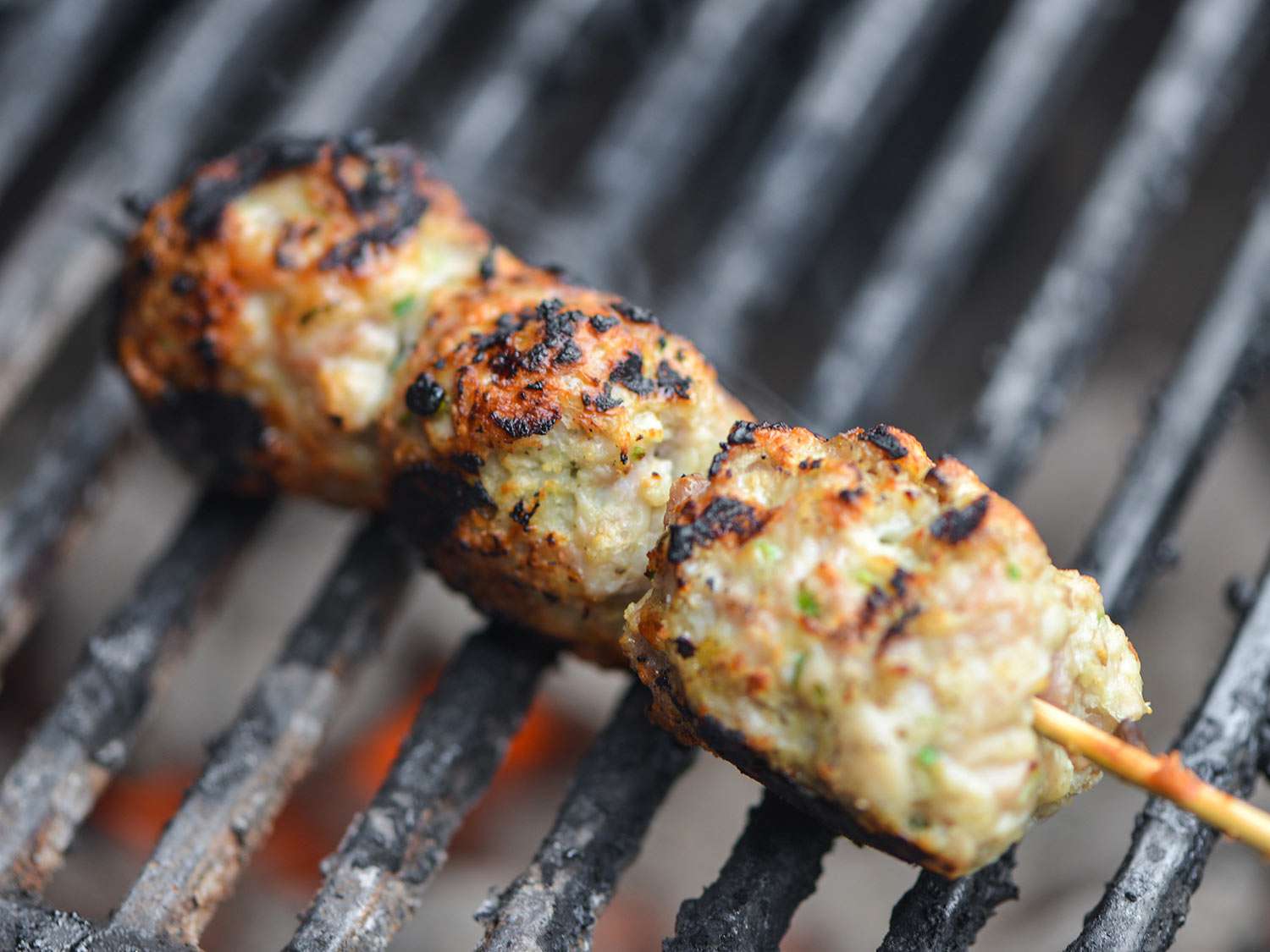 A skewer of Japanese chicken meatballs on the grill. 