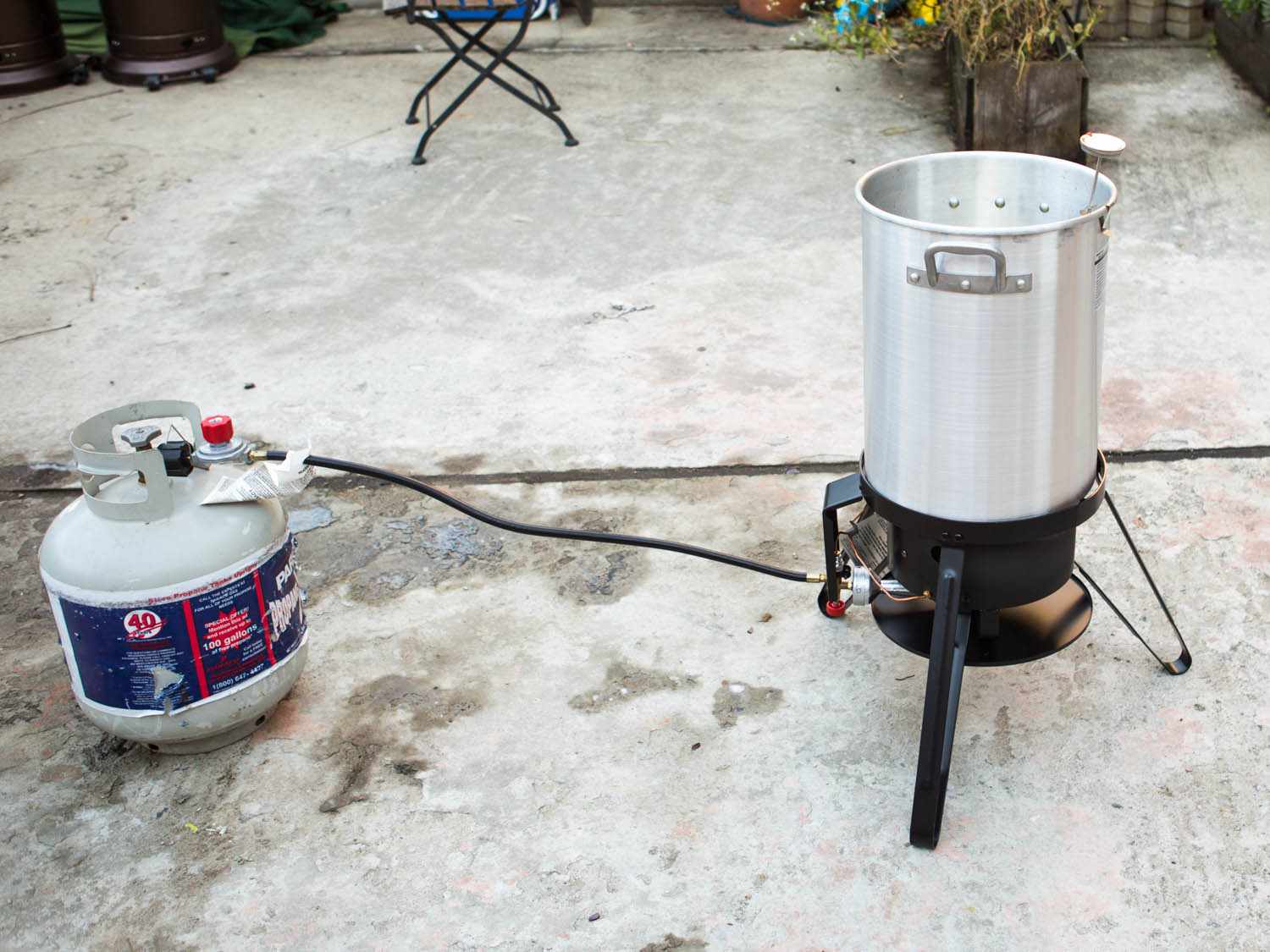 Demonstration of safe distance between propane gas tank and turkey fryer set up.