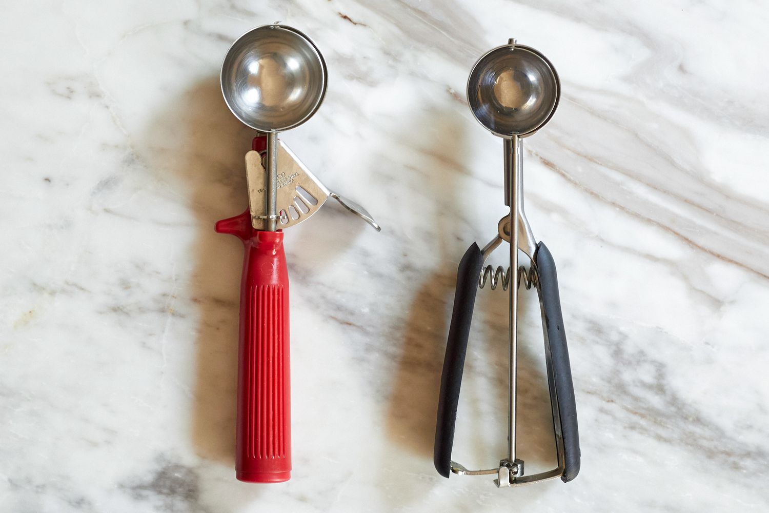 Two portion scoops on a marble surface