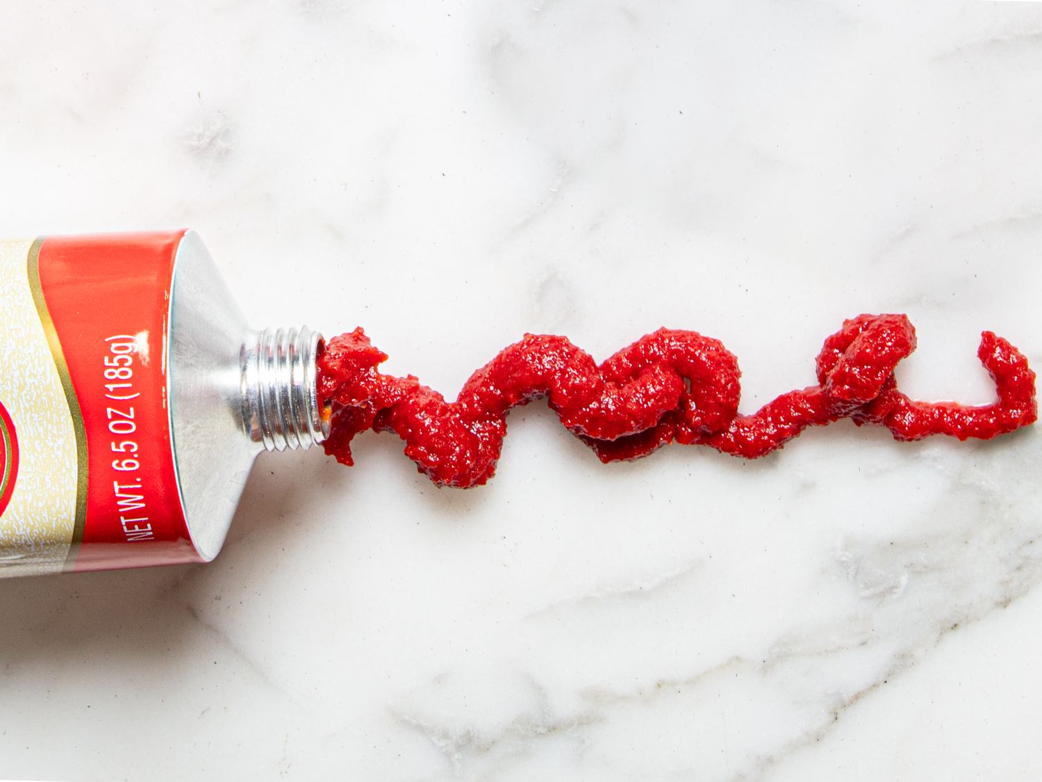 A tube with a red substance squeezed onto a surface