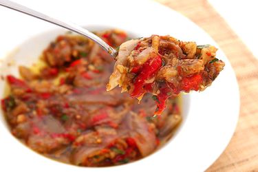 A spoonful of escalivada is held up for the camera.