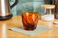 An amber cortado glass on a kitchen countertop.
