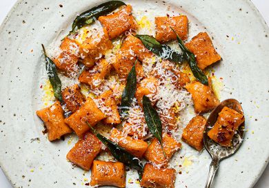 Plate of sweet potato gnocchi topped with grated cheese crispy sage and brown butter