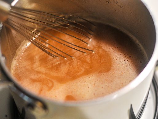 Closeup of the liquid seasoning being whisked together in a saucepan.