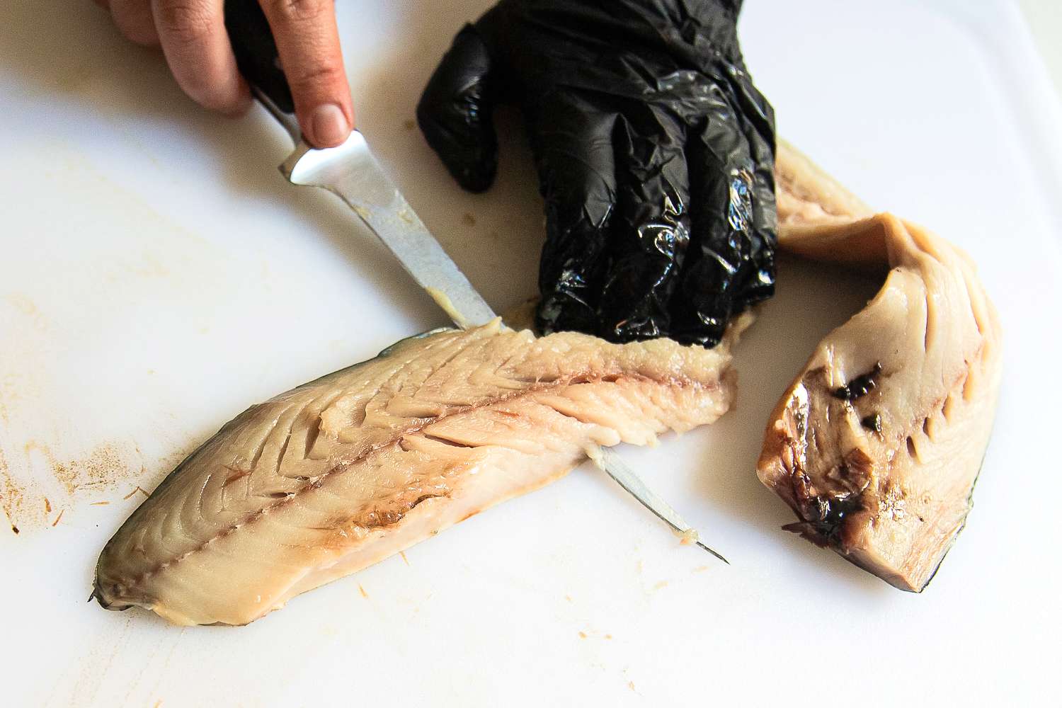 A person using the Wüsthof Classic Fish Fillet Knife to cut a fish