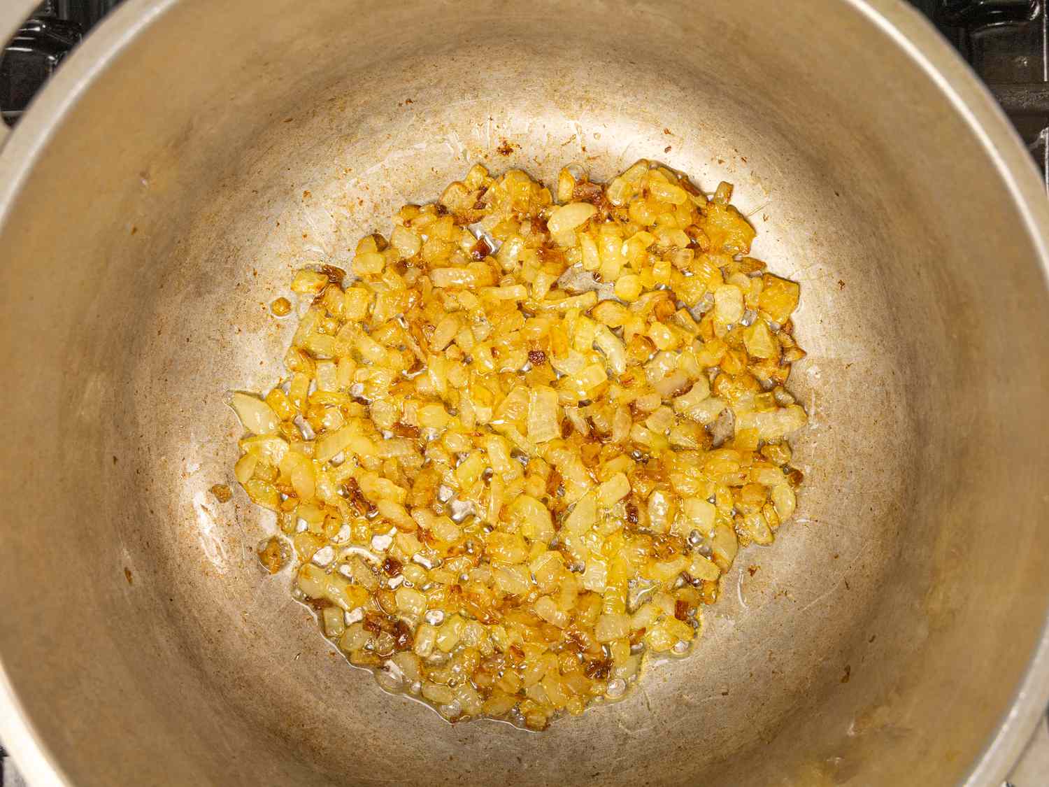 Overhead view of onions browning in a pot