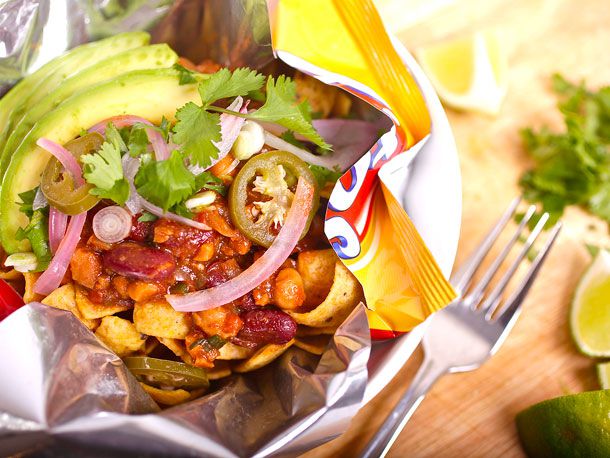 Closeup of a vegan Frito pie, garnished with avocado and cilantro.