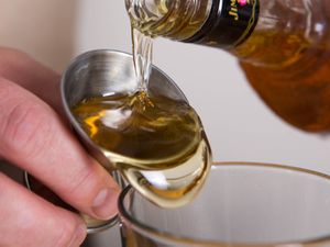 Closeup of bourbon being measured with a jigger.