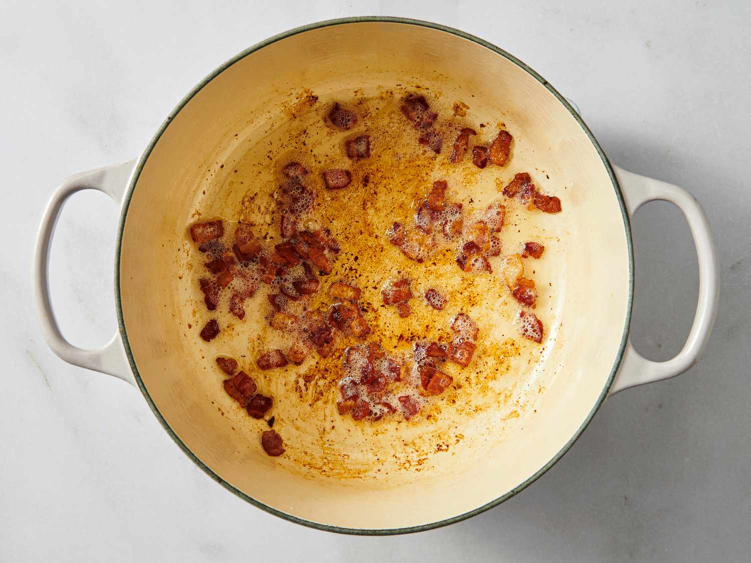 Browning diced bacon in a stew pot