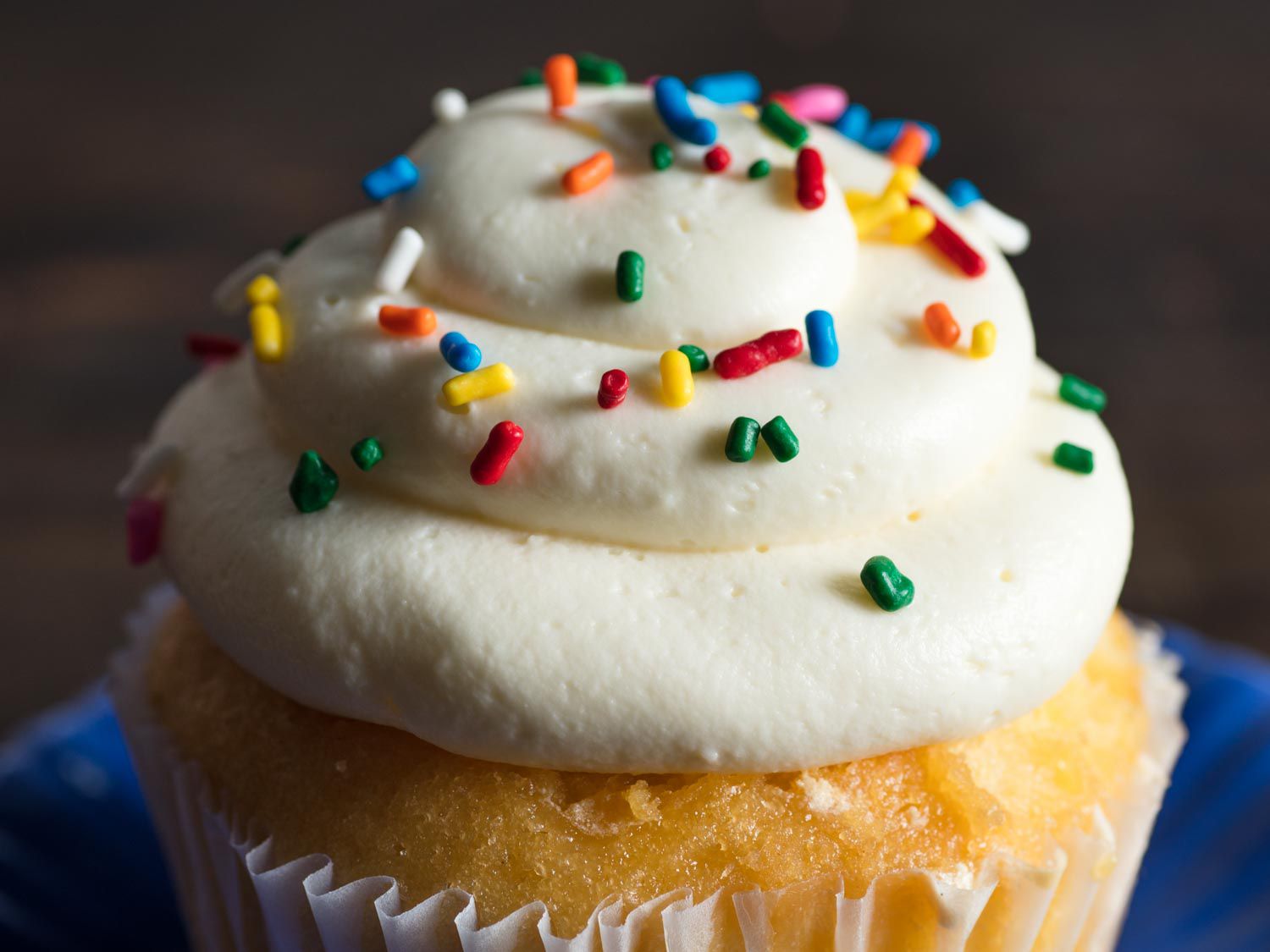 Cream cheese frosting with sprinkles on a cupcake. 