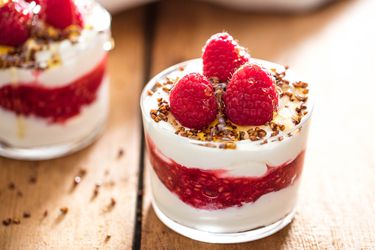 A glass of cranachan topped with fresh raspberries.