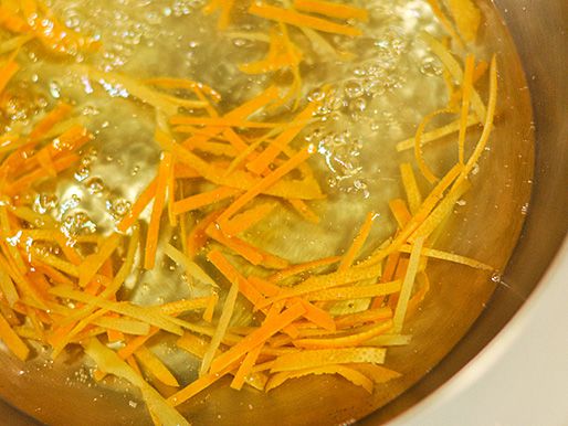 Strips of lemon and orange rinds simmering in water for Cumberland sauce.