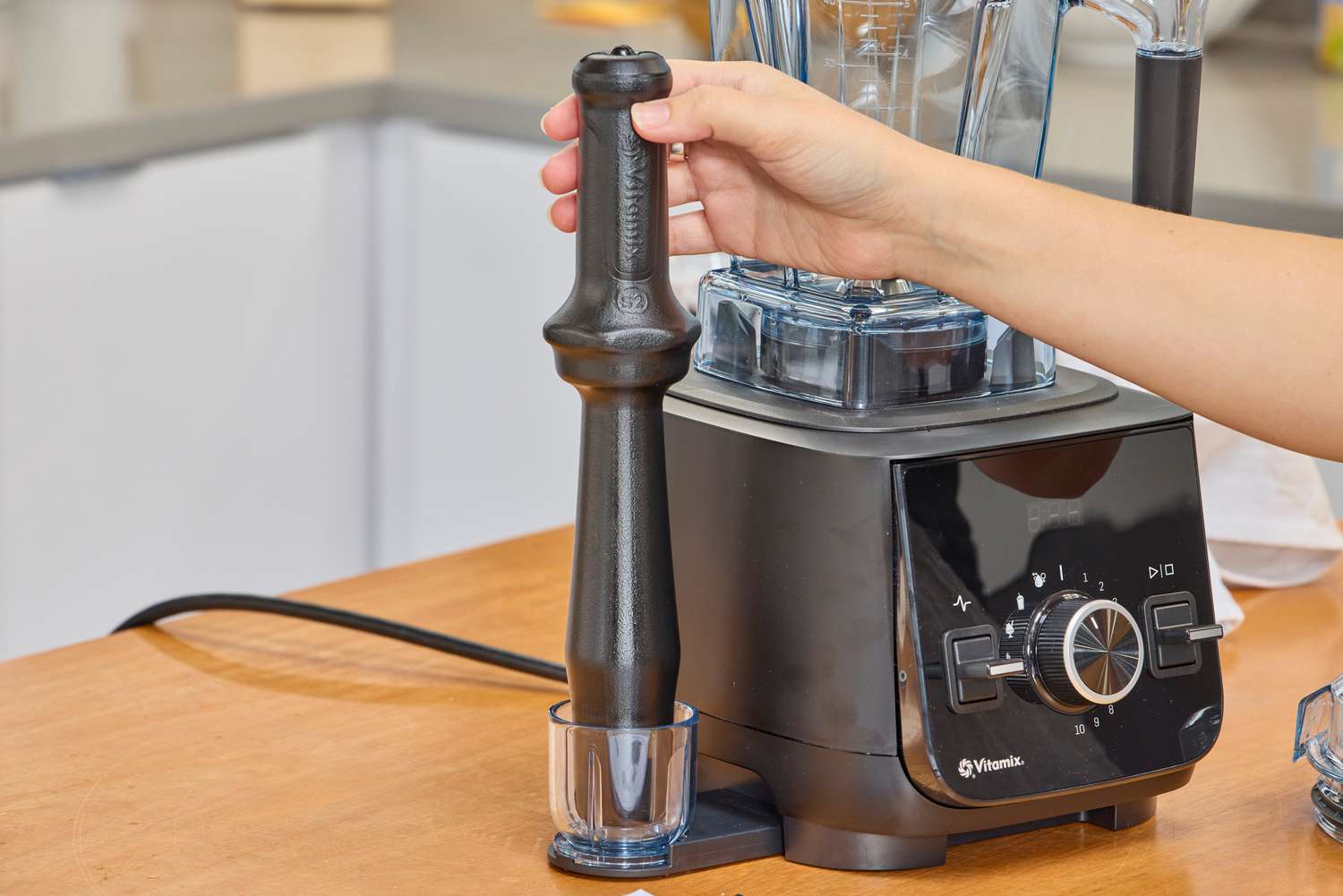 A hand grabbing an accessory from the Vitamix Ascent X2