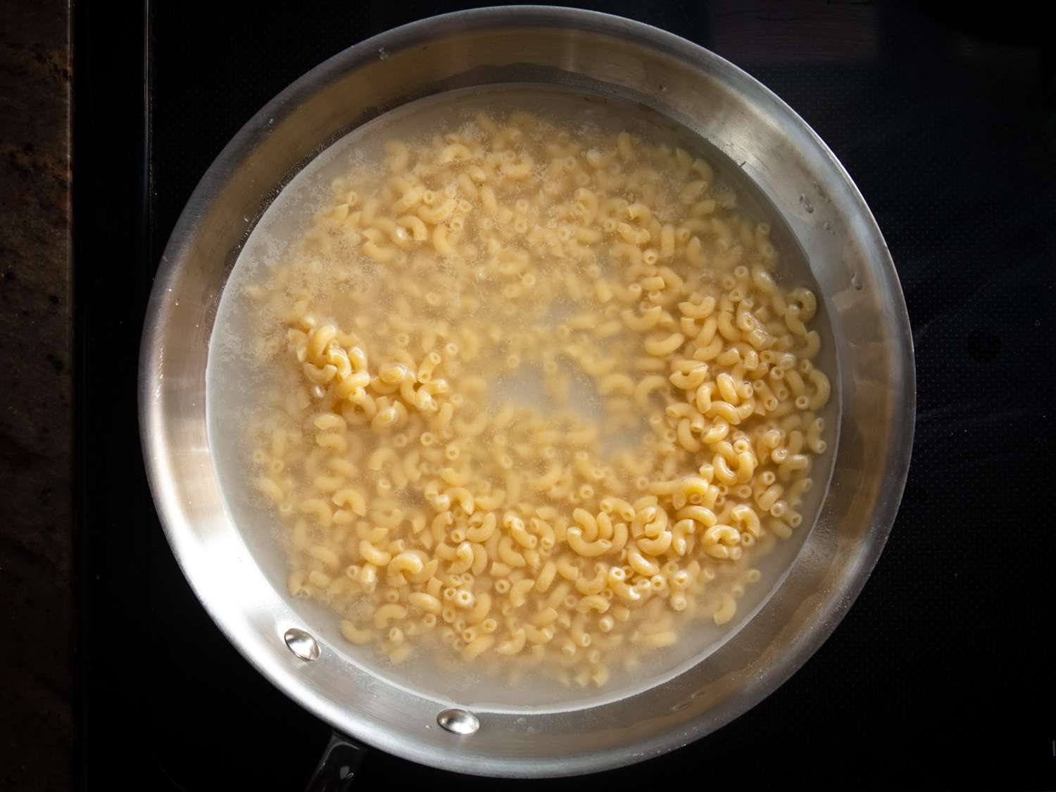 Macaroni elbow pasta cooking in a pot of water 