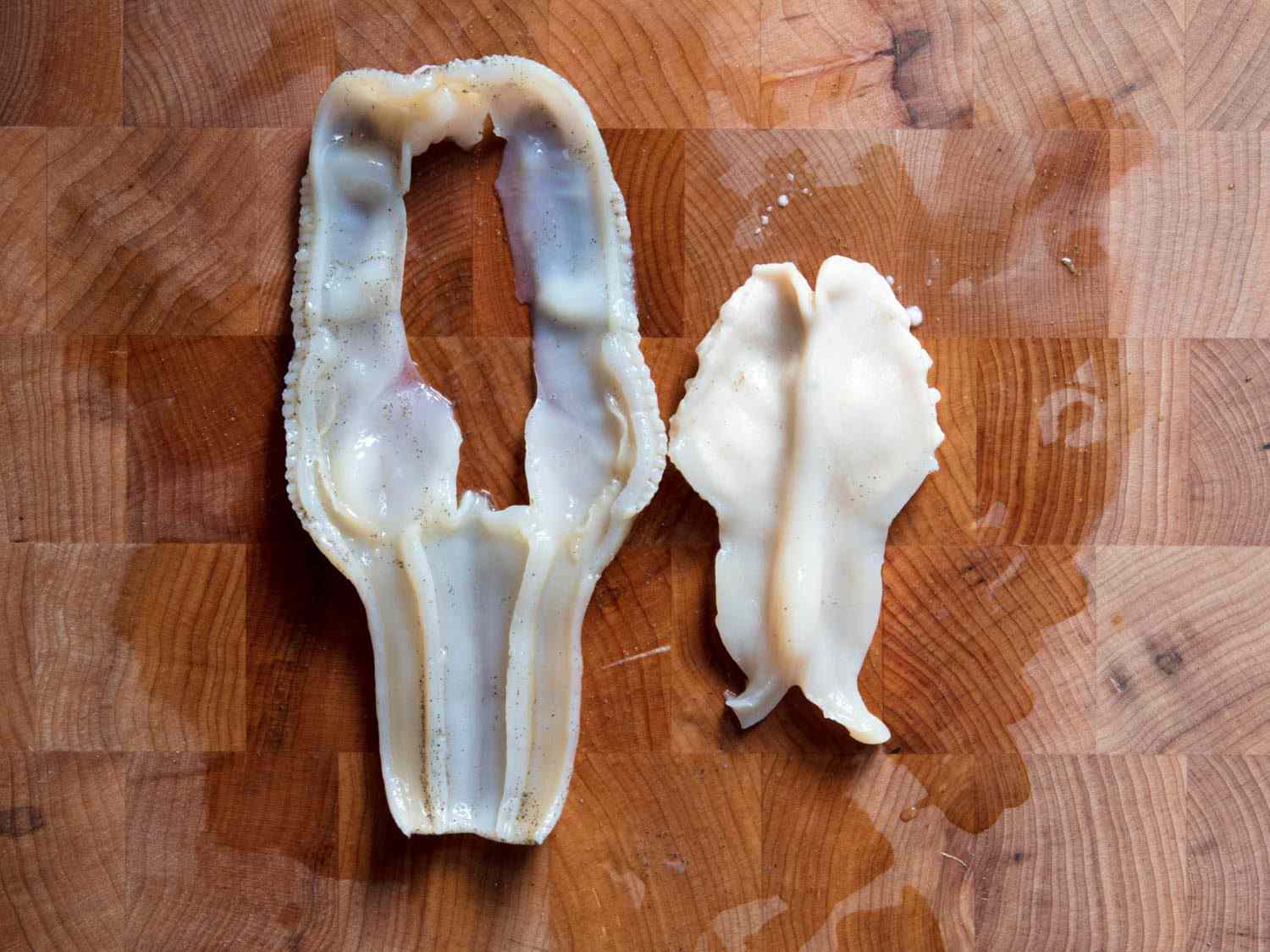 Cleaned razor clam meat on a wooden cutting board.