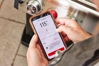 A person adjusts the temperature of the Weber Spirit EX-325s Smart Grill