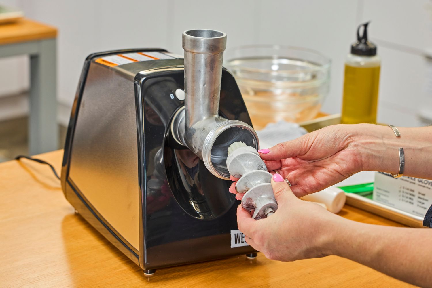 Person placing grind worm in Weston #8 Electric Meat Grinder