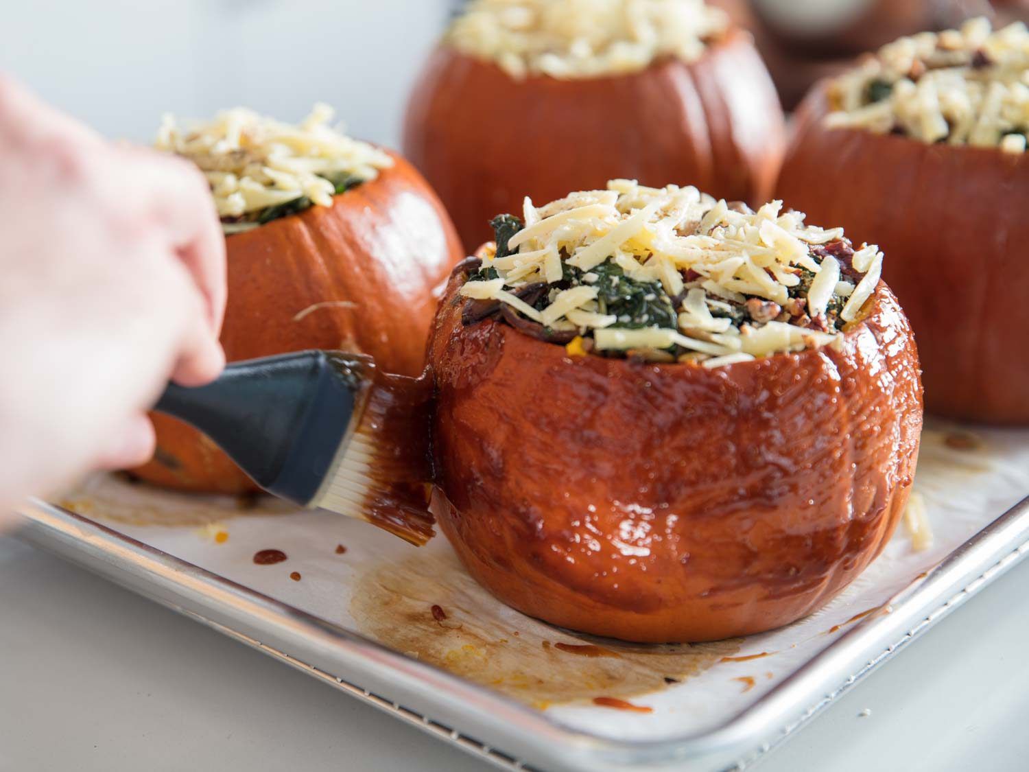 Glazing the exterior of a stuffed pumpkin.