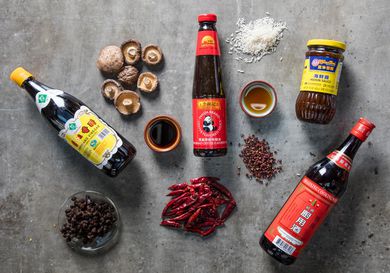 Overhead shot of Chinese culinary ingredients like sauce, mushrooms, and chilies