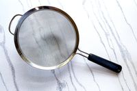 OXO Good Grips 8-Inch Double Rod Strainer on a marbled surface