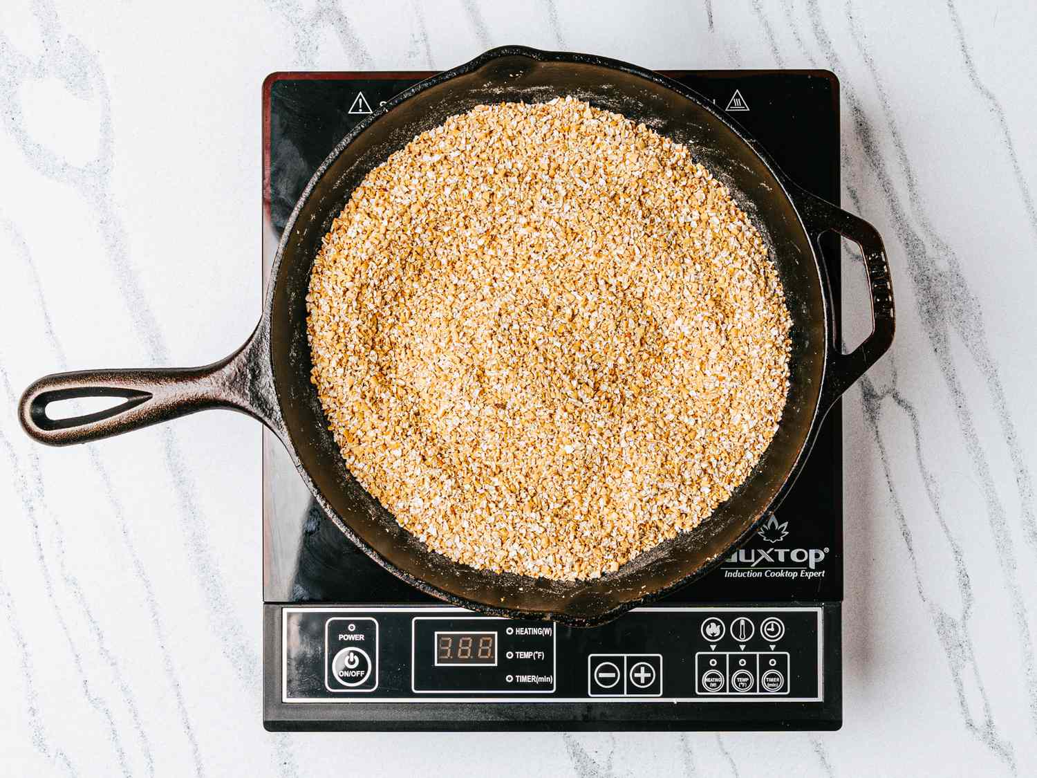 Skillet with oats heating over an induction cooktop