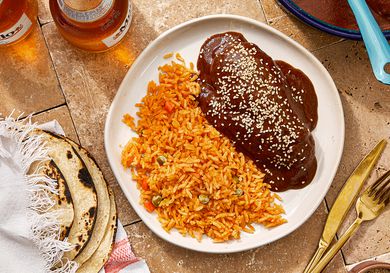 Plate with mole negro and rice served with tortillas on the side