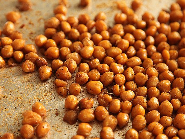 Seasoned roasted chickpeas on a baking tray. 
