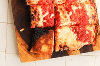 A pizza made in the LloydPans Kitchenware 10 by 14 Inch Detroit Style Pizza Pan