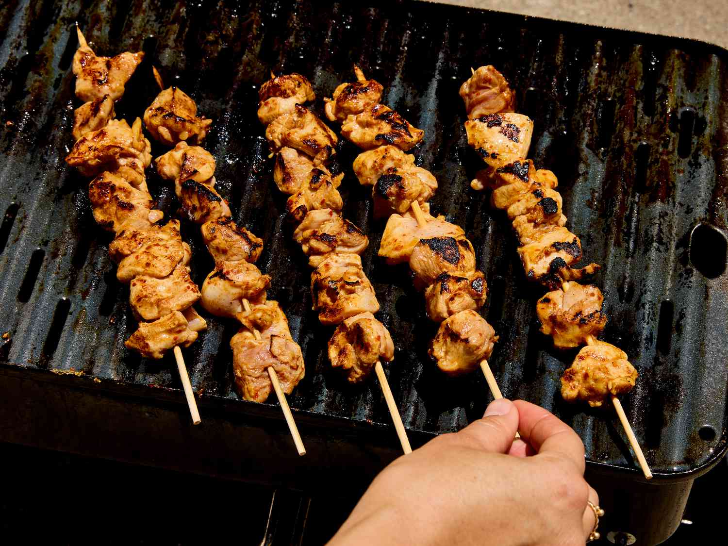 Grilled chicken skewers being cooked on a barbecue grill
