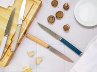 material knives on a white tile surface